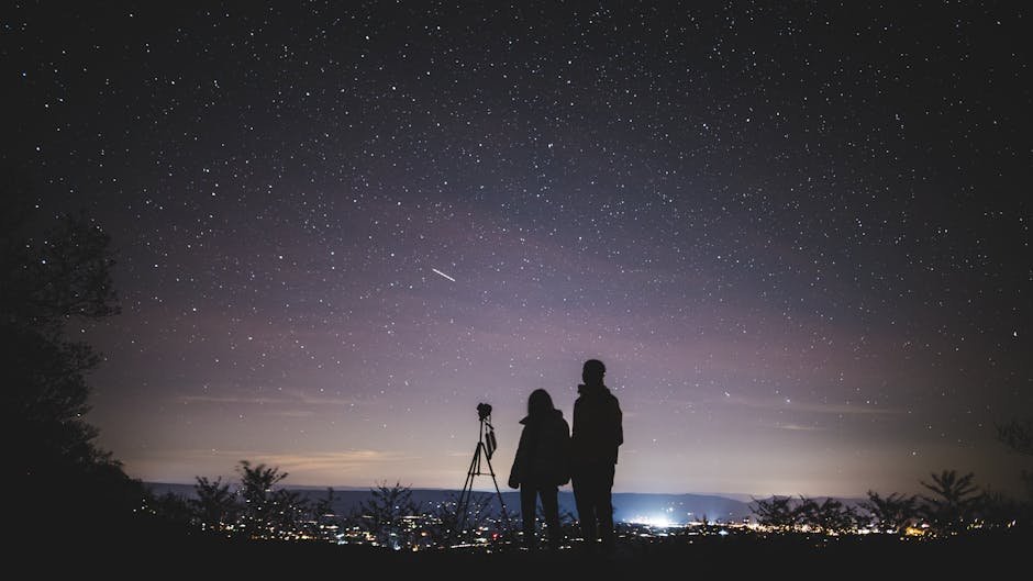 A couple stargazing on a hillside, representing romance and connection for Aquarius