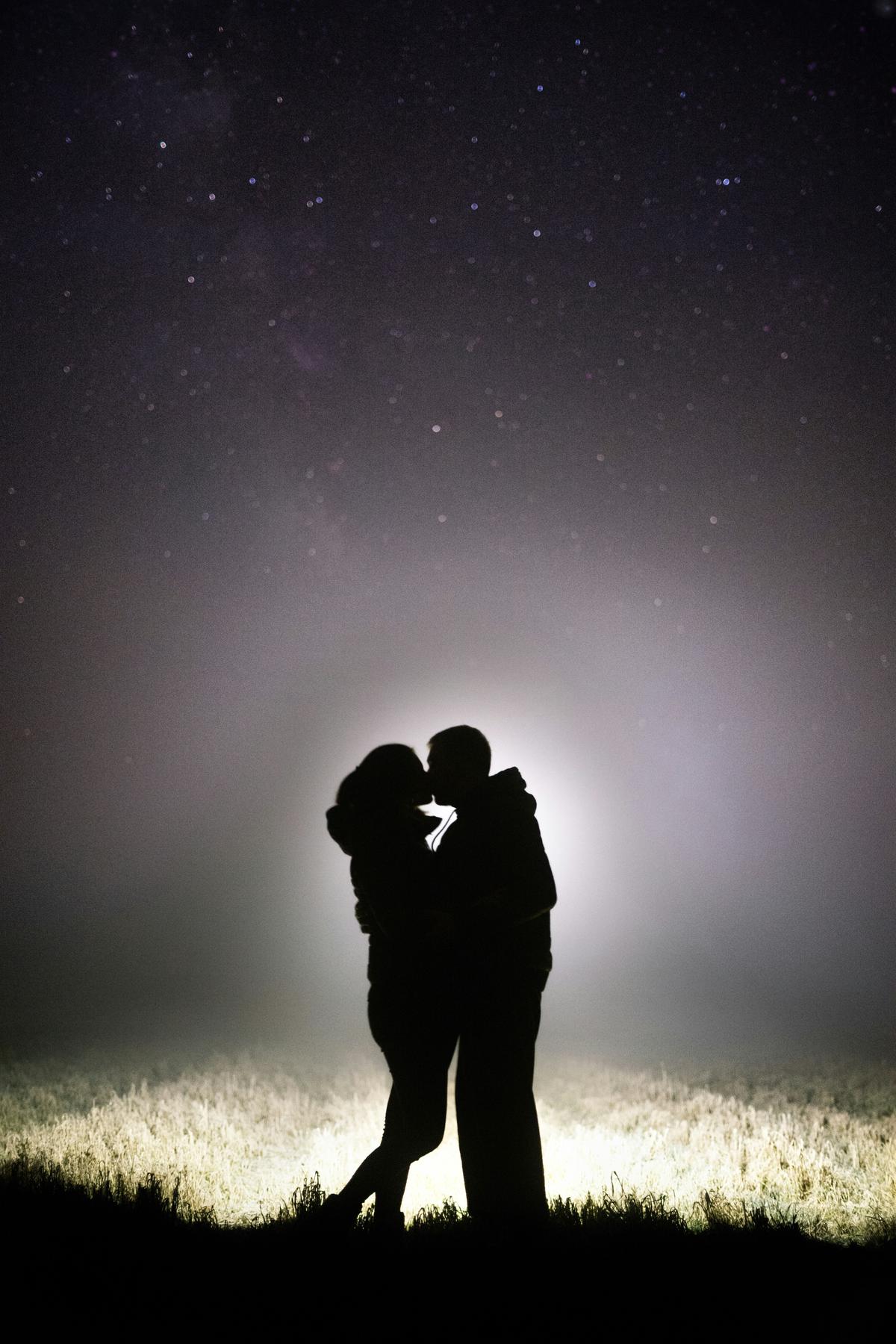 A couple sharing an intimate moment under a starry sky