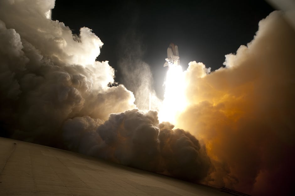 The Artemis II spacecraft launching from Earth, with a fiery rocket plume illuminating the night sky