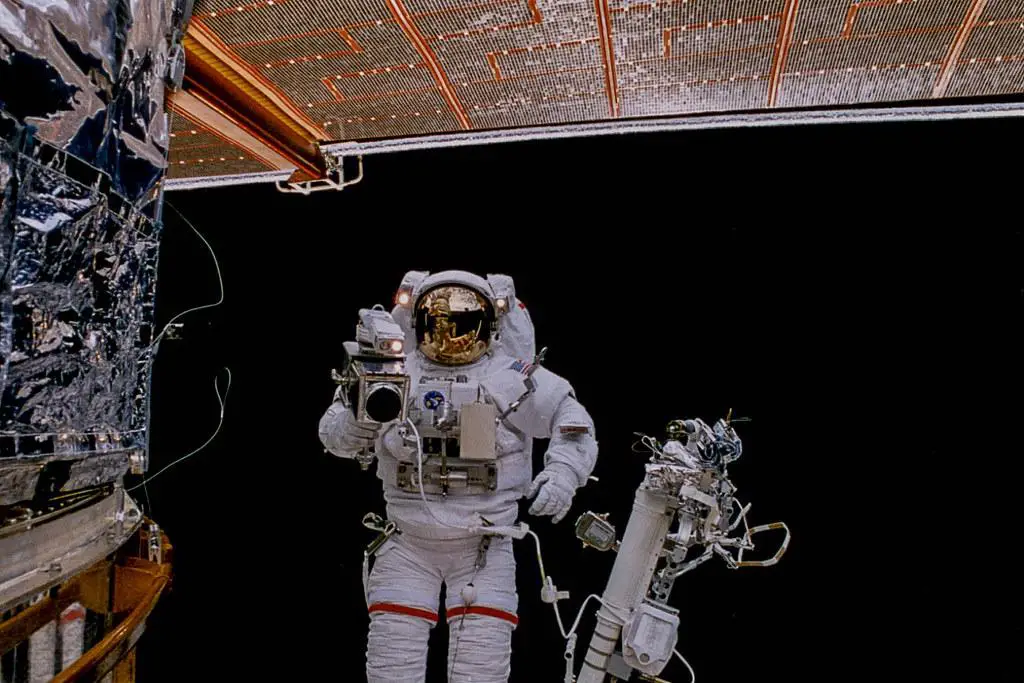 Astronaut performing maintenance on the Hubble Space Telescope during a servicing mission