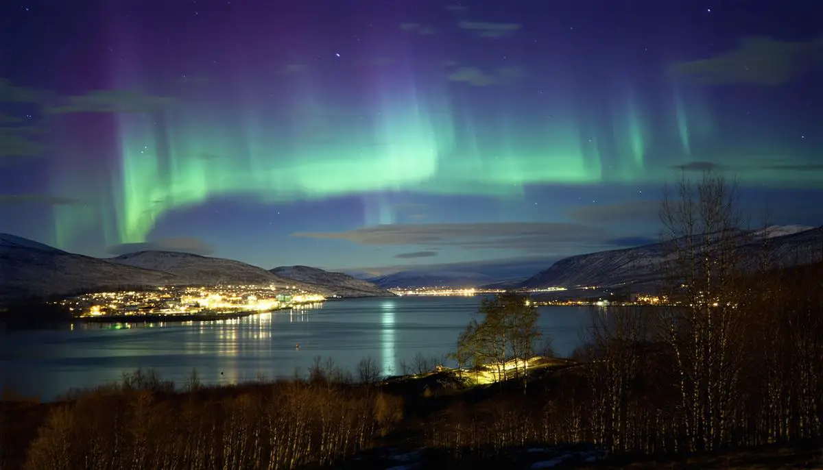 A serene nighttime landscape in Tromsø, Norway with the aurora borealis visible in the sky