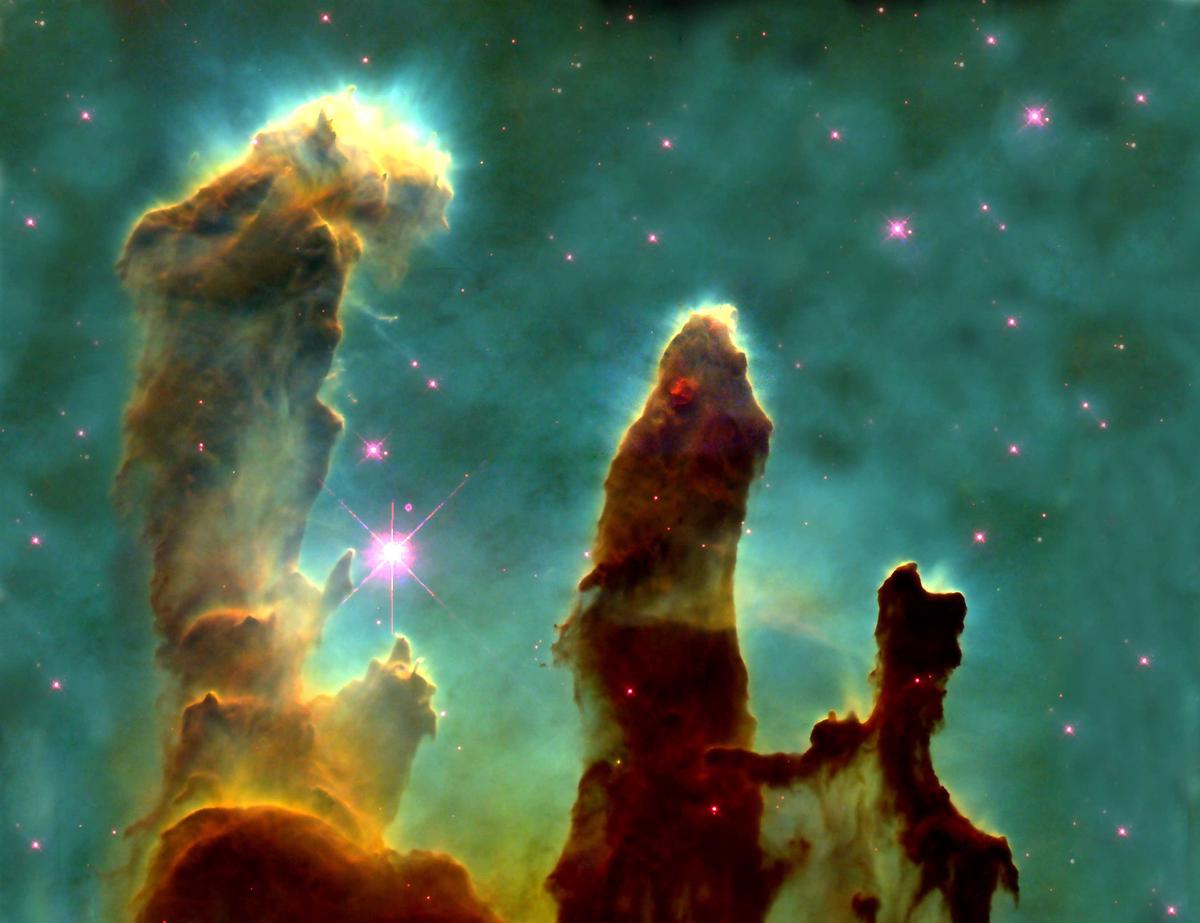 An infrared view of the Eagle Nebula's Pillars of Creation, revealing young stars forming within the dusty structures