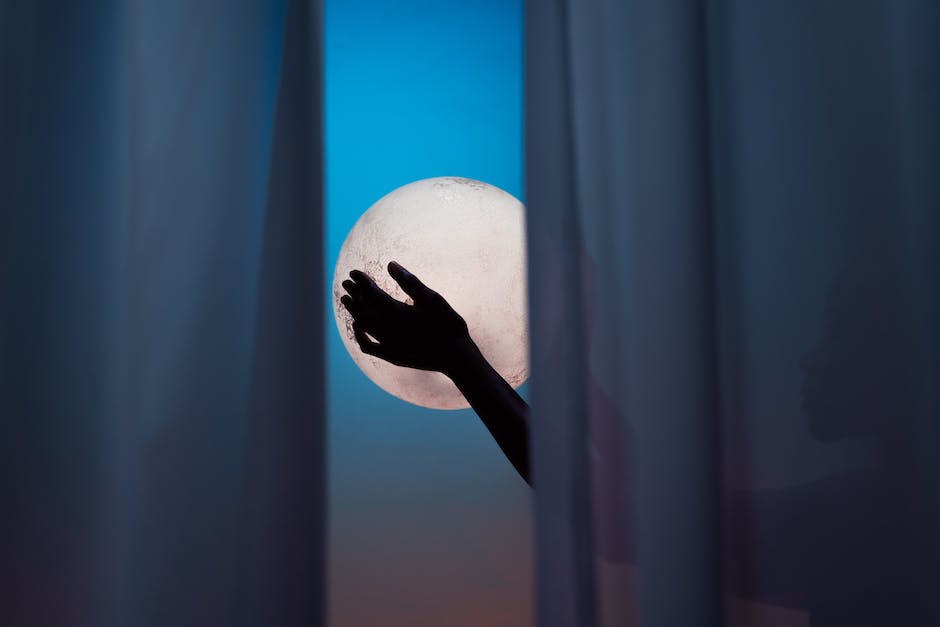Silhouette of a person looking at the full moon and engaging in a spiritual ritual