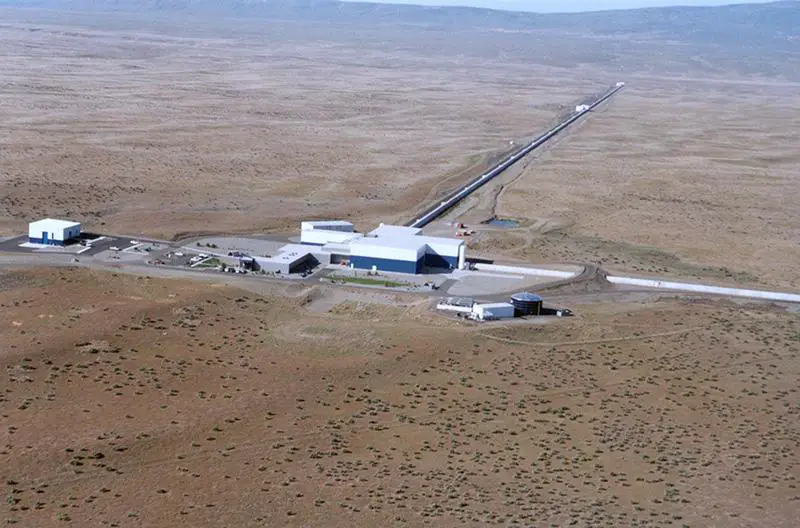 LIGO gravitational wave detector with a visualization of gravitational waves rippling through space-time