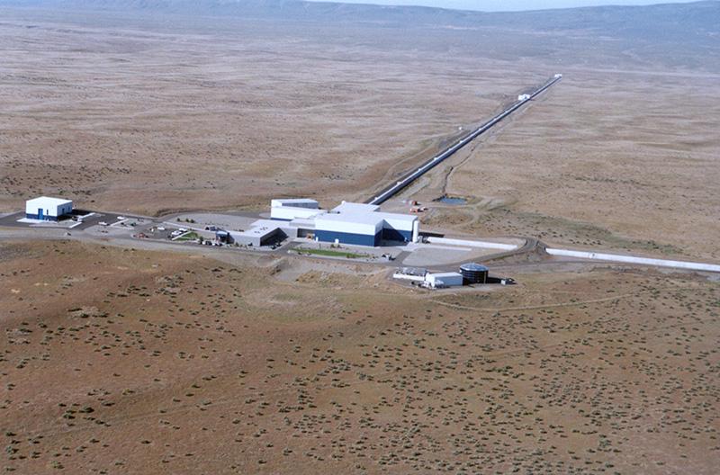 An aerial view of the LIGO gravitational wave detector facility, showing its long arms and intricate laser system
