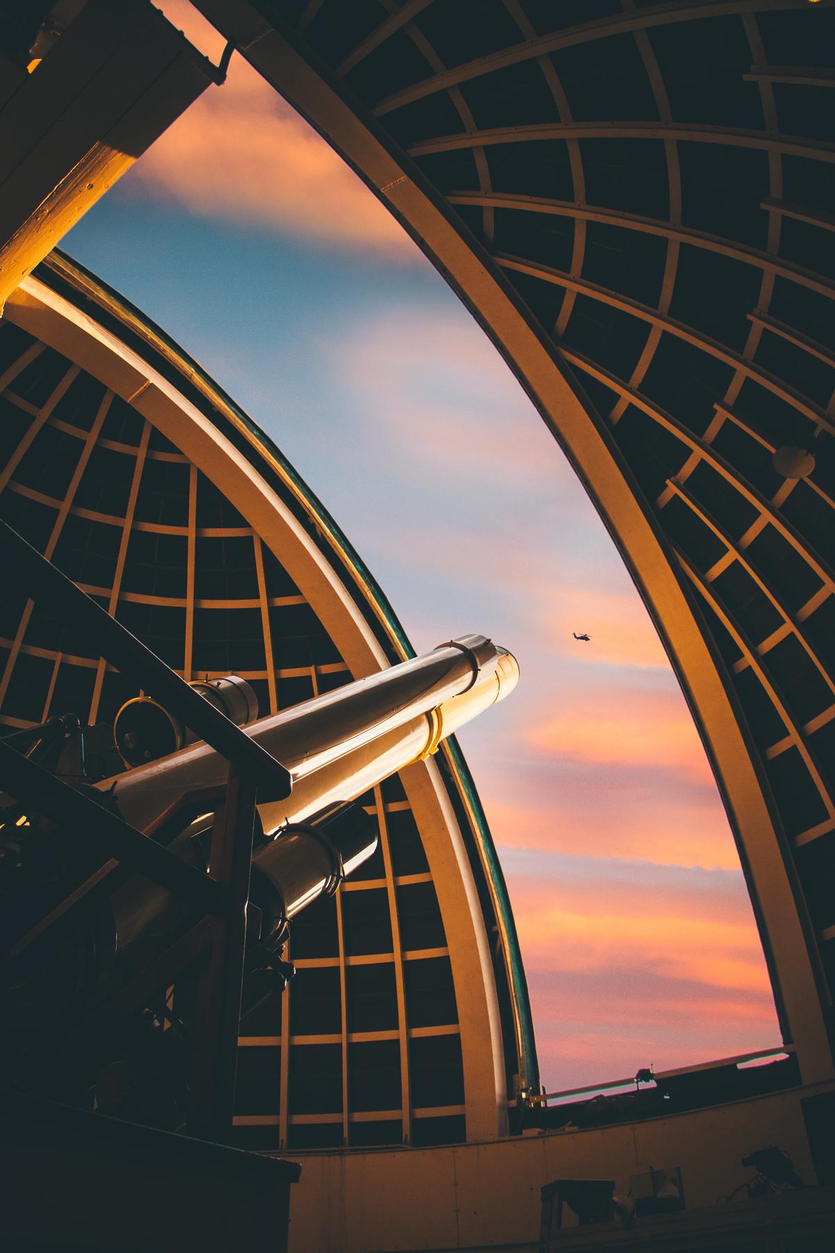 A person observing the moon through a telescope at night