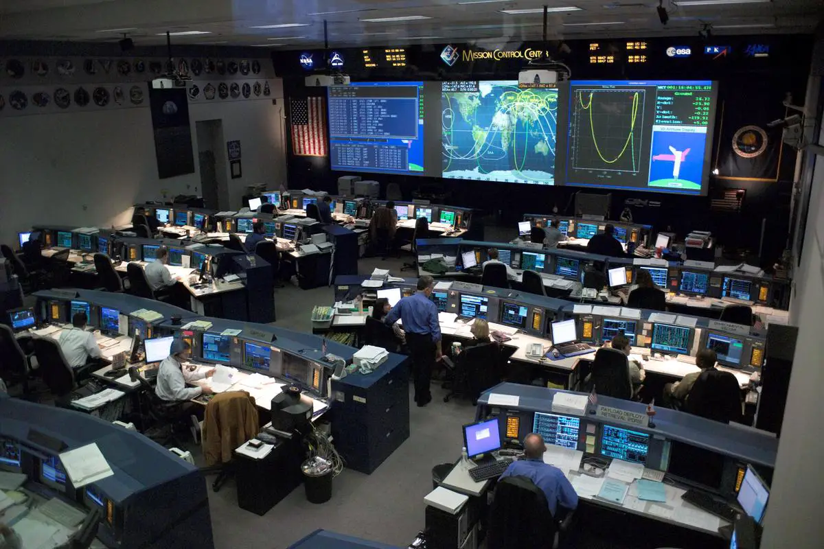 NASA and SpaceX engineers collaborating in a high-tech control room, with screens displaying lunar mission data