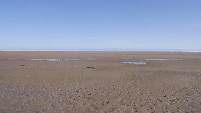 A beach scene during neap tides, showing less pronounced high and low tide marks