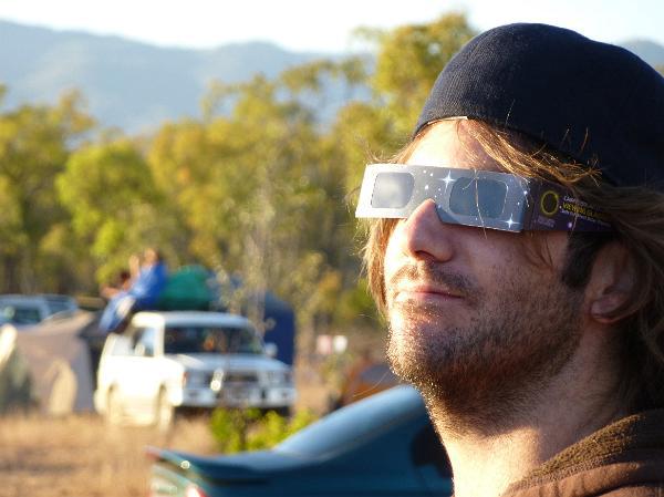 A person demonstrating proper use of solar eclipse glasses