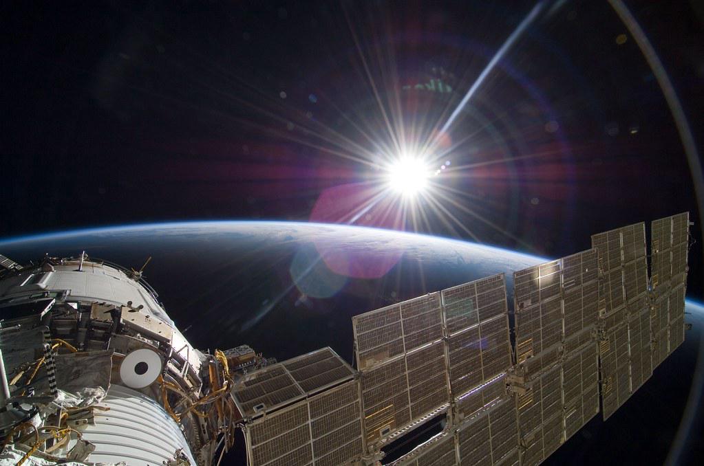 View of the blindingly white sun from the International Space Station, with Earth's curve visible in the foreground