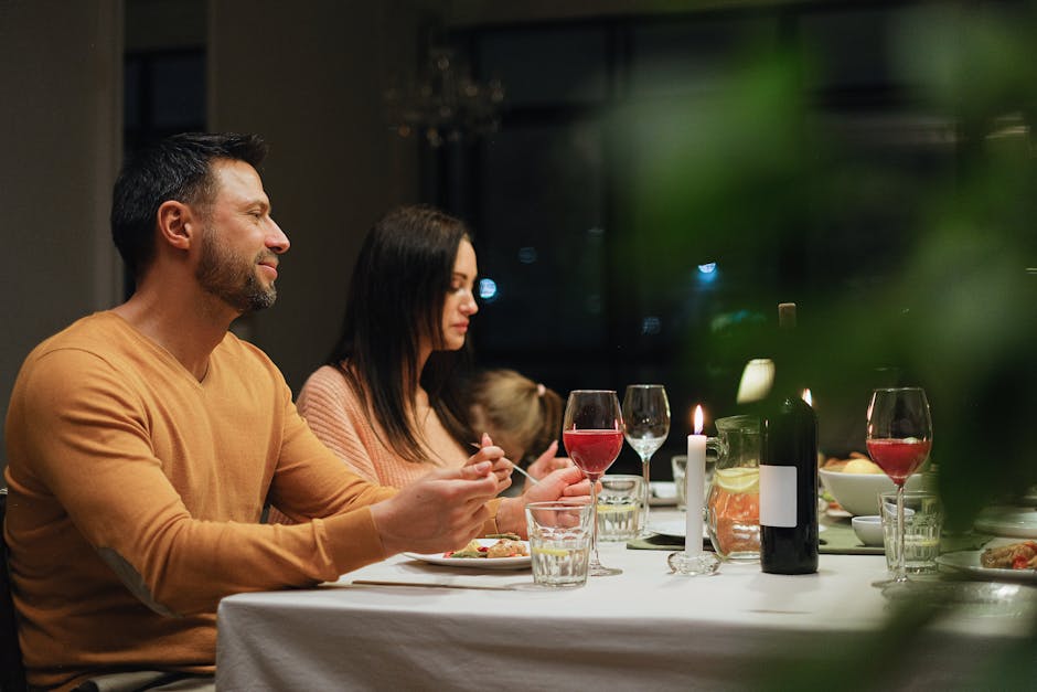 A couple enjoying a romantic homemade dinner with candles and wine