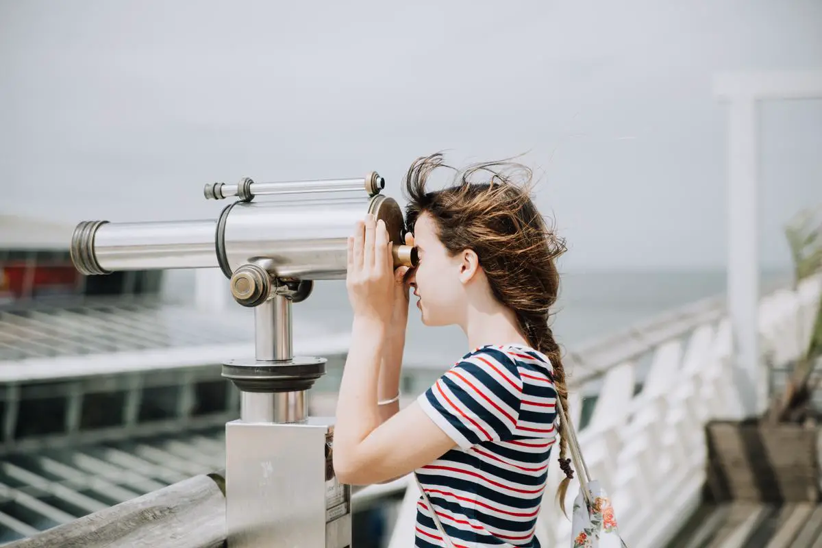 A person looking through a telescope at the night sky with fascination