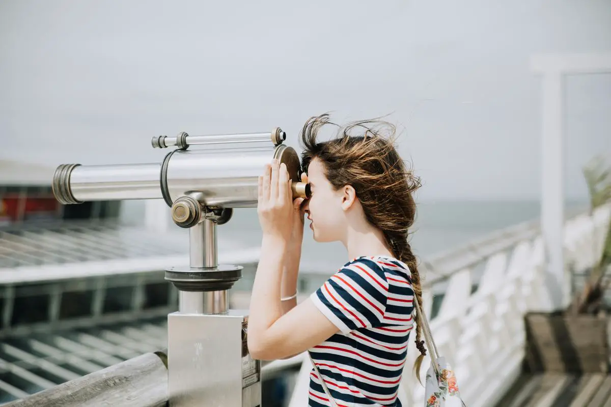 A person with a telescope gazing at the night sky full of stars