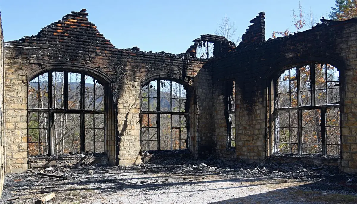 Burnt ruins of the historic Zane Grey Estate, showing charred stone walls and collapsed roof